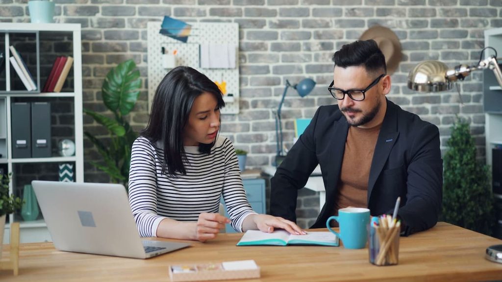 Two coworkers discussing a workplace promotion