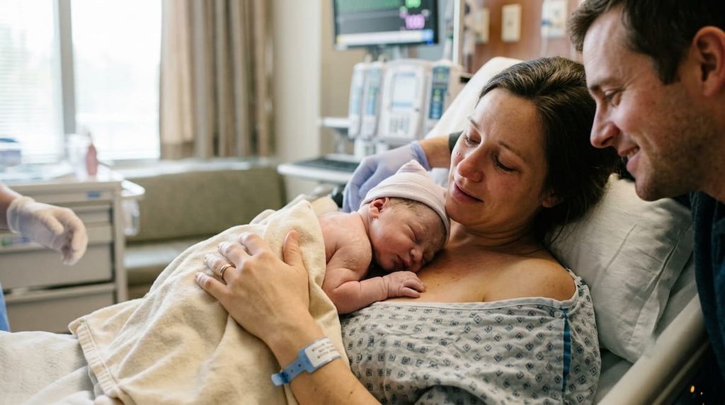 Newborn baby resting on a parent's chest after birth