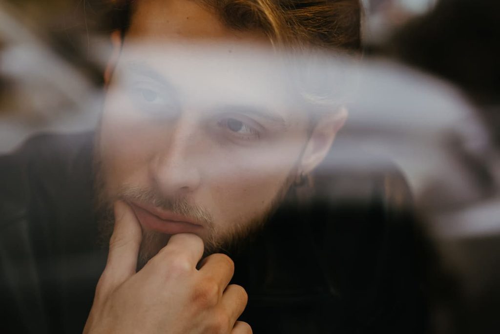 A person sitting quietly while dealing with persistent thoughts.