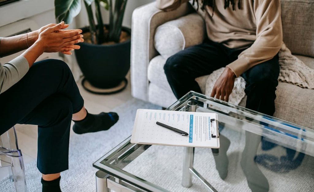 An adult speaking with a mental health therapist during a consultation.